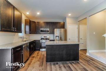 Lancaster house for rent - a kitchen with dark wood cabinets and granite counter tops and a stainless steel refrigerator