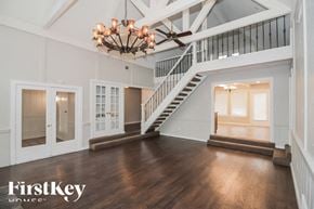 Memphis house for rent - A spacious room with a staircase and a chandelier.