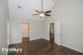 Memphis house for rent - A room with a ceiling fan and wooden floors.