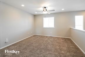 Aurora house for rent - a bedroom with a carpeted floor and a ceiling fan