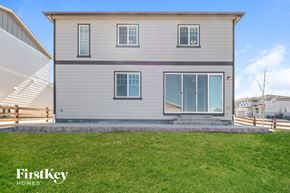 Aurora house for rent - front view of a white house with white siding and green grass