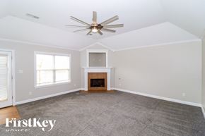 Oakland house for rent - A spacious living room with a fireplace and a ceiling fan.