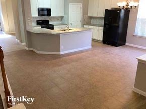 San Antonio house for rent - an empty kitchen with an island and a black refrigerator