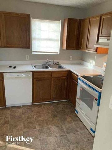 Clermont house for rent - A kitchen with brown cabinets and a white dishwasher.