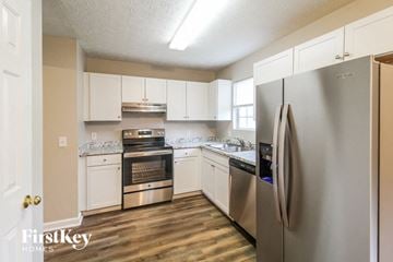 Gainesville house for rent - a kitchen with stainless steel appliances and white cabinets