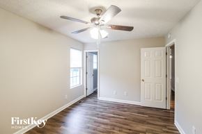 Gainesville house for rent - a living room with wood floors and a ceiling fan
