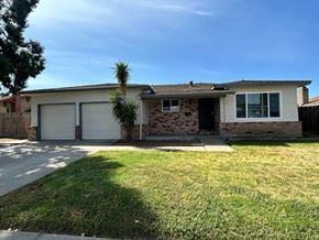 Manteca house for rent - A house with a white garage door and a brick chimney.
