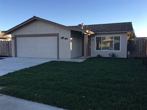 Manteca house for rent - A house with a white garage door and a brown roof.