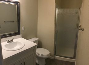Manteca house for rent - A bathroom with a toilet, sink, and shower.