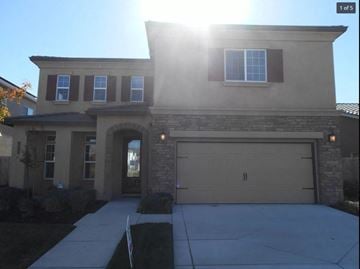 Manteca house for rent - A house with a garage and a driveway.