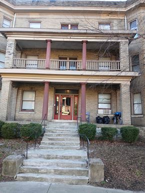 Louisville apartment for rent - A brown building with a red door and steps leading up to it.