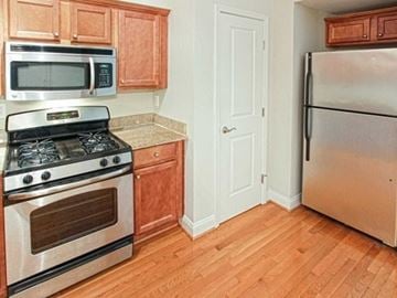Piermont apartment for rent - A kitchen with wooden cabinets and a stainless steel refrigerator.