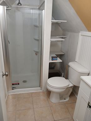 Louisville apartment for rent - A white toilet in a small bathroom with a walk-in shower.