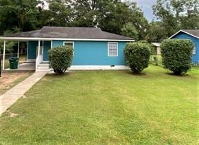 Petal house for rent - A blue house with a green trash can in front of it.