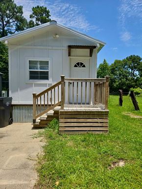 Hattiesburg apartment for rent - A small white house with a brown porch.