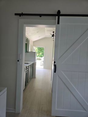 Hattiesburg apartment for rent - A white barn door opens to a kitchen.