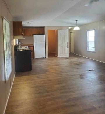 Hattiesburg apartment for rent - A kitchen with a black fridge and wooden floors.