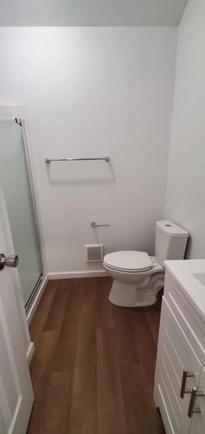 Hattiesburg apartment for rent - A white toilet in a small bathroom with wood flooring.