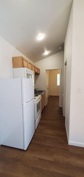 Hattiesburg apartment for rent - A kitchen with white appliances and wooden floors.
