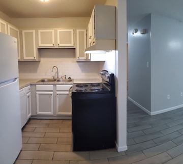 Hattiesburg apartment for rent - A kitchen with a black dishwasher and white appliances.