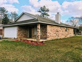 Hattiesburg house for rent - A house with a white garage door and a chimney.