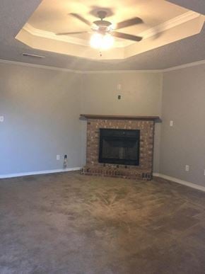 Hattiesburg house for rent - A living room with a fireplace and a ceiling fan.