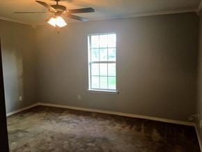 Hattiesburg house for rent - A room with a ceiling fan and a window.