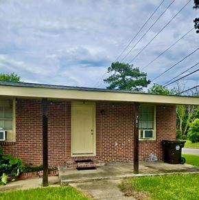 Hattiesburg apartment for rent - A house with a brown brick wall and a white door.