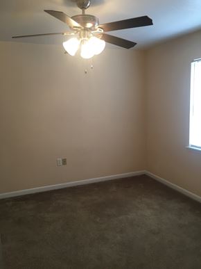 Hattiesburg apartment for rent - A room with a ceiling fan and a light fixture.