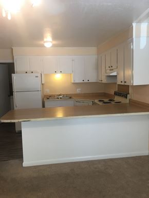 Hattiesburg apartment for rent - A kitchen with white cabinets and a white refrigerator.