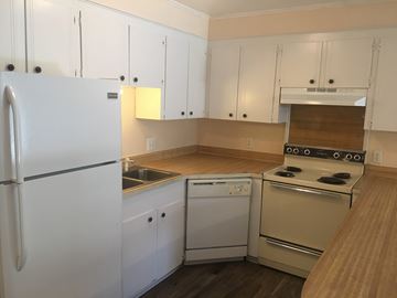 Hattiesburg apartment for rent - A white refrigerator is in a kitchen with white cabinets.