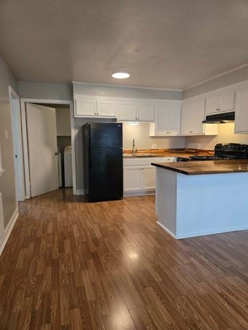 Hattiesburg apartment for rent - A kitchen with a black fridge and wooden floors.