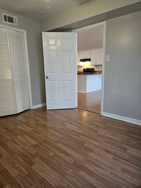 Hattiesburg apartment for rent - A room with a white door and wooden flooring.