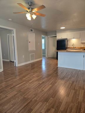 Hattiesburg apartment for rent - A room with a ceiling fan and wooden flooring.