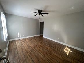 Hattiesburg house for rent - a living room with wood floors and a ceiling fan