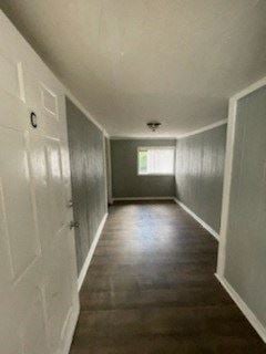 Hattiesburg apartment for rent - A long hallway with a white door on the left and a window on the right.
