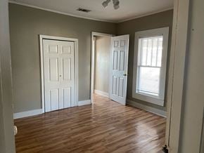 Petal house for rent - an empty room with wood floors and two doors and a window