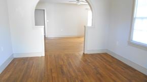 Hattiesburg house for rent - an empty living room with wooden floors and white walls