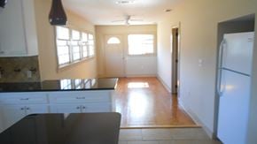 Hattiesburg house for rent - an empty kitchen with white cabinets and a refrigerator