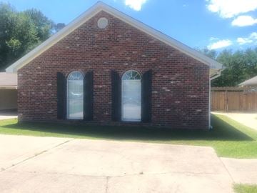Hattiesburg apartment for rent - A small red brick house with a white door and two windows.