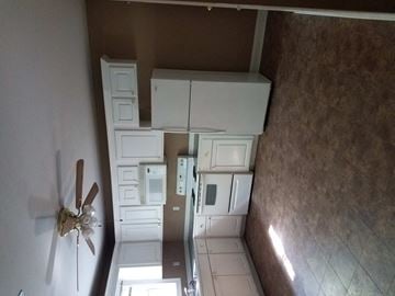 Purvis apartment for rent - a kitchen with white cabinets and a ceiling fan