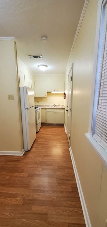 Hattiesburg apartment for rent - a kitchen with white cabinets and a wood floor