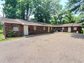 Hattiesburg apartment for rent - a brick house with a gravel driveway and trees