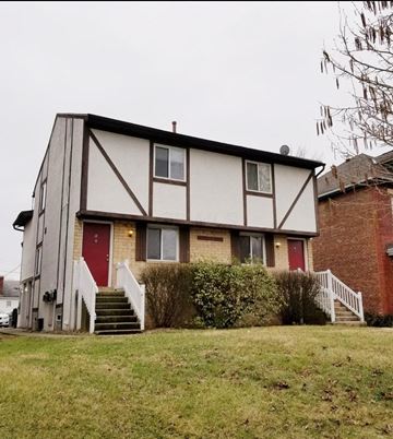 Columbus apartment for rent - a white house with red doors and a brick building
