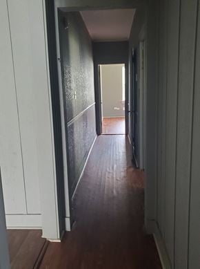 Hattiesburg apartment for rent - a hallway with wood floors and white walls and a door