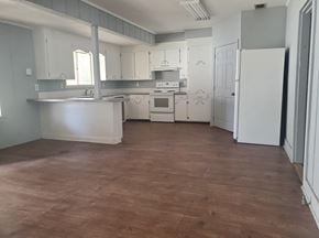Hattiesburg apartment for rent - an empty kitchen with white cabinets and a wood floor