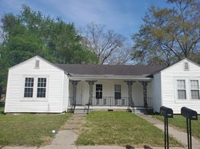 Hattiesburg apartment for rent - the front of a white house with a porch and a lawn