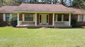 Seminary house for rent - a small brick house with a porch and a lawn
