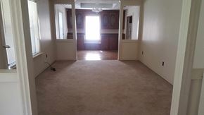 Seminary house for rent - an empty living room with a carpeted floor and a door to a bedroom