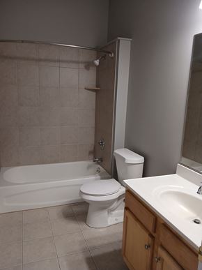Louisville apartment for rent - A white toilet sits next to a bathtub in a bathroom.